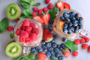 Mason jars with fruits and berries on table