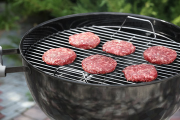 Barbecue grill with tasty patties on backyard