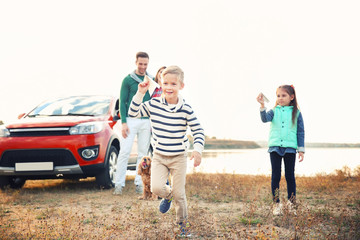 Cute children playing and parents near car, outdoors