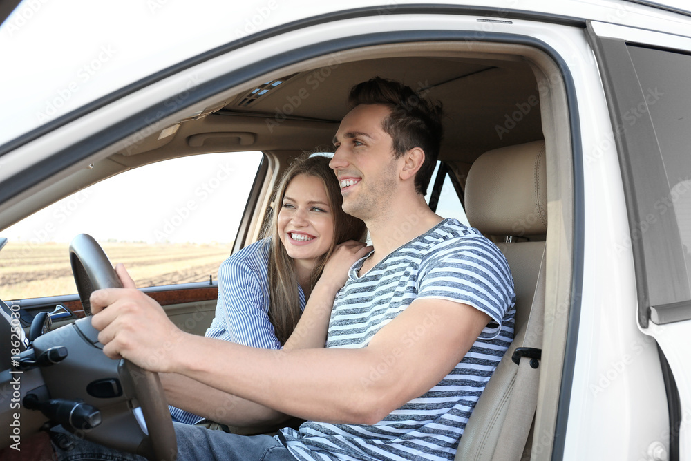 Poster beautiful young couple in car