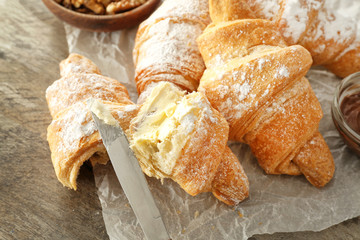 Tasty sweet croissants on table