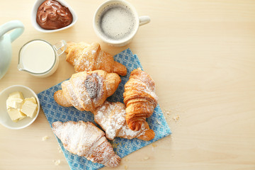 Composition with tasty croissants, milk and coffee on table