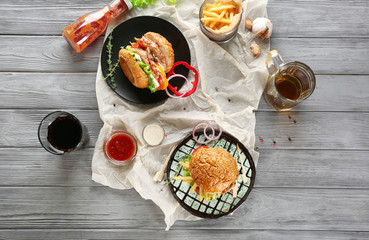 Composition with tasty double burgers on wooden table