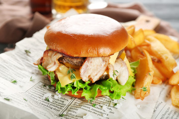 Tasty double burger on newspaper, closeup