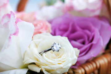 Engagement ring with flowers in wicker basket, close up