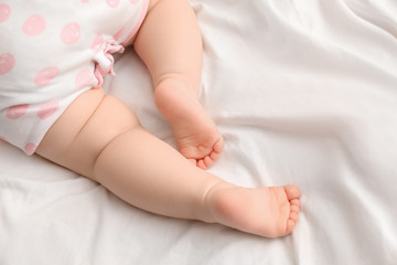 Cute little baby on bed, closeup of legs