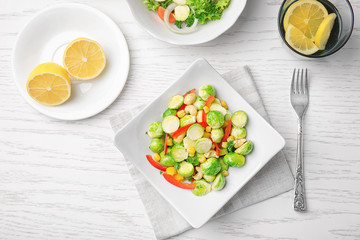 Plate of tasty salad with Brussels sprouts on table
