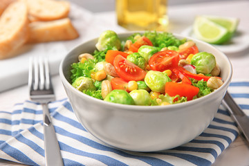 Bowl of tasty salad with Brussels sprouts on table