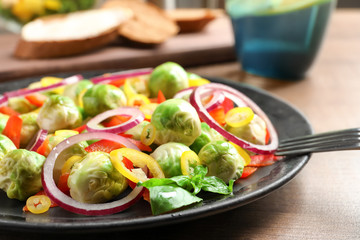 Plate with yummy brussel sprouts salad on table