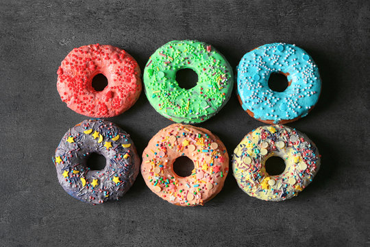 Fresh yummy colorful donuts on grey background