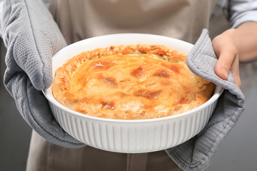 Woman holding freshly baked apple pie, closeup