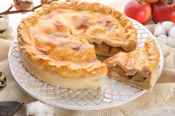 Ornate dish with freshly baked apple pie on table