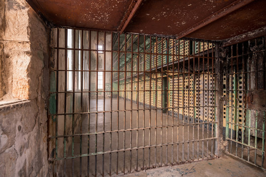 Jail cell corridor with painted and rusted bars