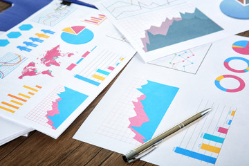 Documents with graphs and charts on table
