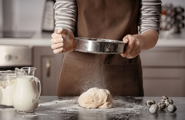 Woman making dough on table