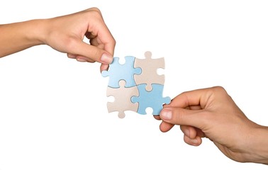 Closeup on Hands Combining Puzzle Pieces Together
