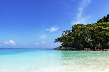 Golden yellow sand on a deserted beach near the blue sea in bright Sunny day.