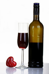 Valentine's Day with a bottle of wine with a rose and Valentin hart sitting on a reflated table top