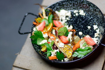 Frying pan with grilled vegetables and cheese.