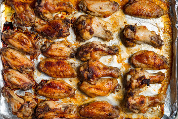 Obraz na płótnie Canvas Chicken wings baked in a pan on white background isolated. Top flat, from above.