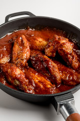 Chicken Wings BBQ in pan with red sauce. Fast food menu background isolated.
