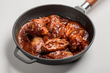 Chicken Wings BBQ in pan with red sauce. Fast food menu background isolated.