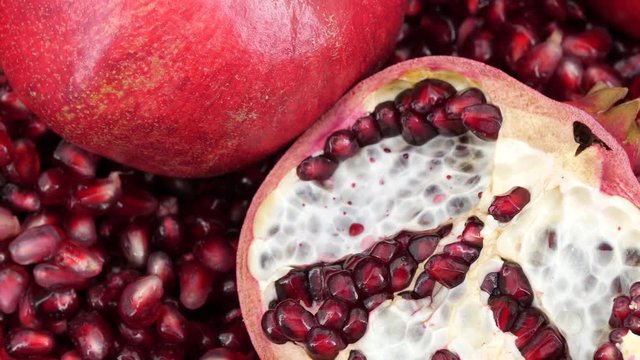 Rotating pomegranate fruit and seeds, top view, 4K.