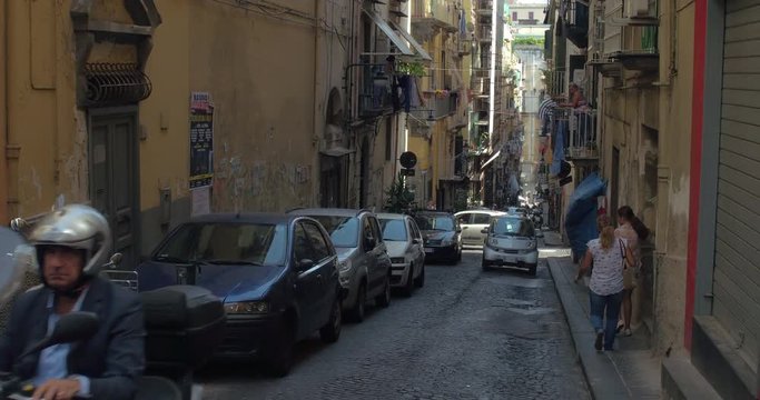 NAPLES, ITALY &ndash; JULY 2016 : Video shot of street in downtown Naples on a sunny day with traffic, bikers and people in view