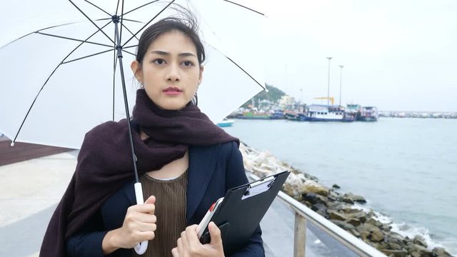 Asian business woman holding umbrellas while walk. 