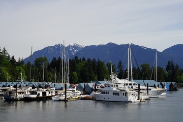 Fototapeta na wymiar Yachts at the Burrard Inlet, Vancouver, Canada with Mountains in the background