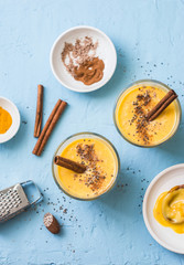 Pumpkin pie spice smoothie with cinnamon and turmeric on a blue background, top view. Healthy diet drink. Flat lay