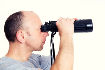 man in gray shirt looking  through a binoculars