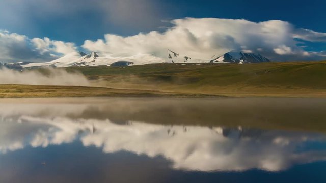 Foggy summer sunrise over mountain lake. Russia, Altai, Plateau Ukok