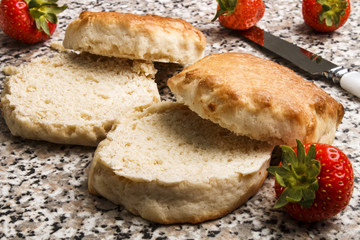 sliced scones and fresh strawberries with knife