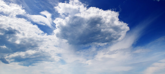 Beautiful clouds slowly flying in the sky. Wide photo.