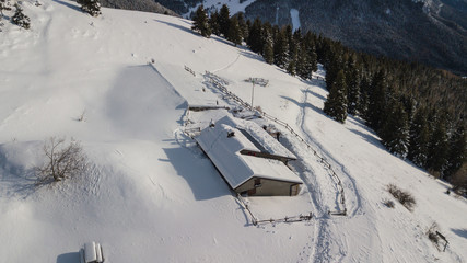 Drone aerial view of the lodge Cassinelli after a snow fall. Italian Alps