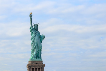 Fototapeta na wymiar The Statue of Liberty on Liberty Island in New York City. It is the copper statue which is a gift from the people of France to the United States. She holds a torch above her head.