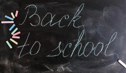 Colorful wallpaper pattern with colored chalks on blackboard back to school concept background 