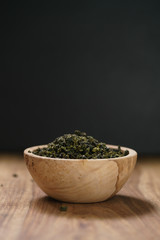 dry organic green oolong tea in wood bowl