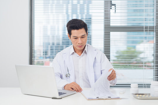 Male doctor working at desk in doctor's room