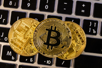 Fototapeta na wymiar Top view stack of three golden Bitcoins Cryptocurrency on computer keyboard. Cryptocurrency concept