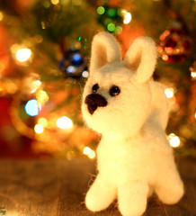 Symbol of new years 2018 white husky dog. Bolt. New years greetings background. Fancy handmade toy from wool on bokeh Christmas background. Copyspace for congratulations.