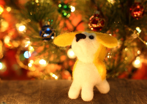 Symbol of new years 2018 yellow dog. Bolt. New years greetings background. Fancy handmade toy from wool on bokeh Christmas background. Copyspace for congratulations.