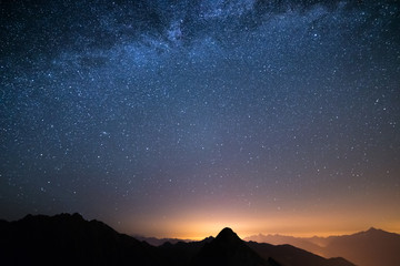 The wonderful starry sky on Christmas time and the majestic high mountain range of the Italian...