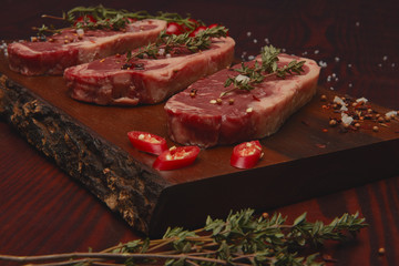Beef steaks on cutting board .