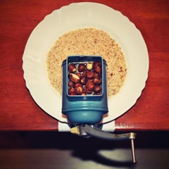 Nice old mill on a table with a plate. Milling nuts for baking sweet desserts and Christmas cookies. View from above