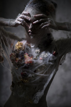 Portrait of sad woman in white veil with web posing at camera