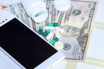 banknote with dollar money, mobile phone, tablets, bottled medicines on bonnots,