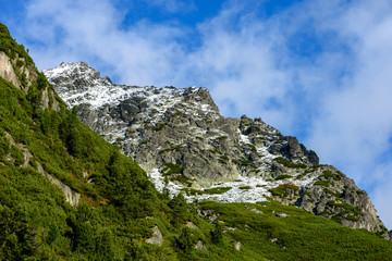 slovakian carpathian mountains in autumn. green hills with tops covered in first snow and white clouds above