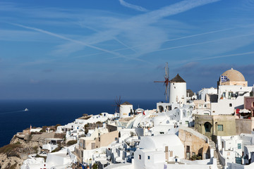 Fototapeta na wymiar Old Town of Oia on the island Santorini, white houses, windmills and churchs with blue domes